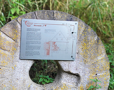 Informationstafel auf einem alten Mühlstein vor der Mühle © LAG Region an der Romantischen Straße e. V.